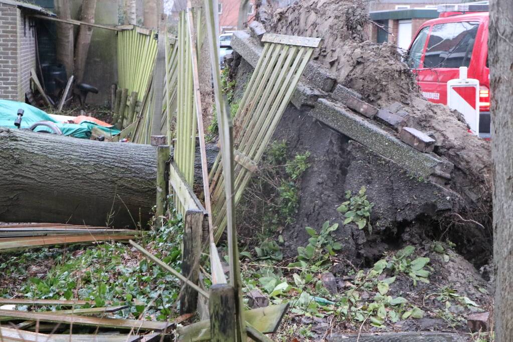 Grote boom valt op woningen en schuur