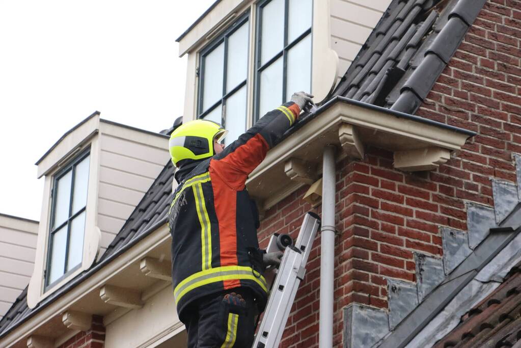 Brandweer verwijdert losse dakpannen van woning