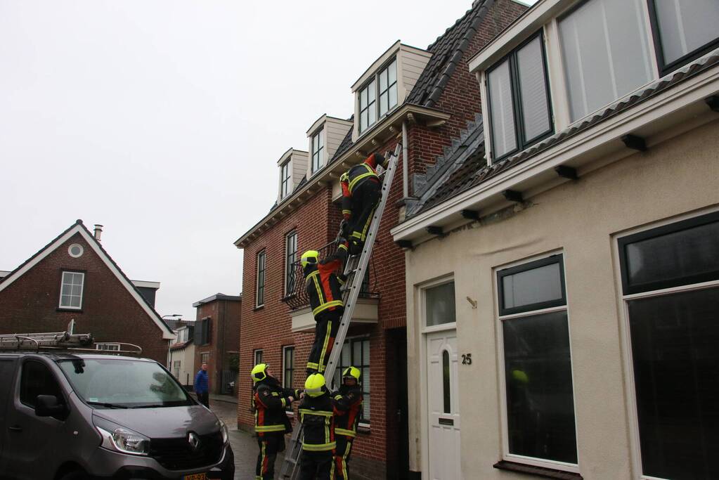 Brandweer verwijdert losse dakpannen van woning