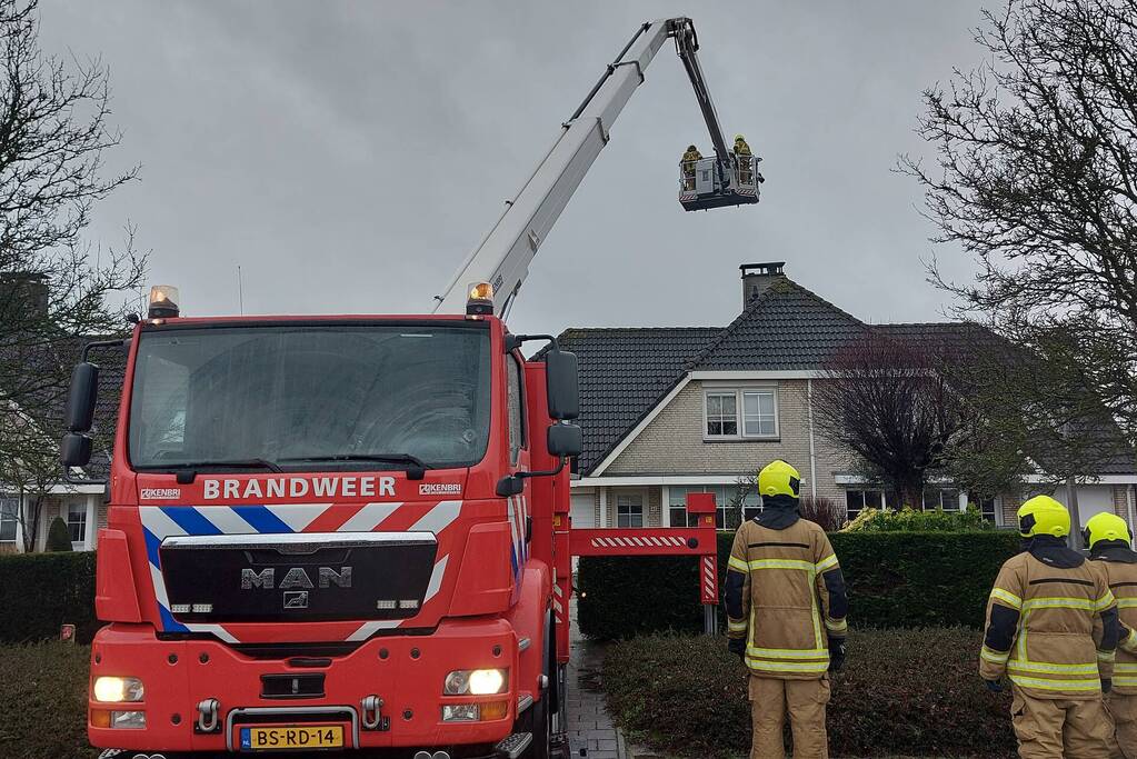 Brandweer verwijderd losse plaat op schoorsteen van woning