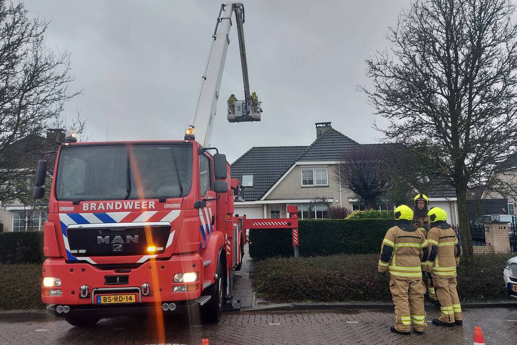 Brandweer verwijderd losse plaat op schoorsteen van woning