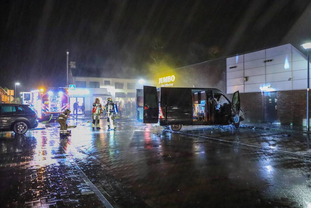 Bestelbus in brand tegen gevel Jumbo