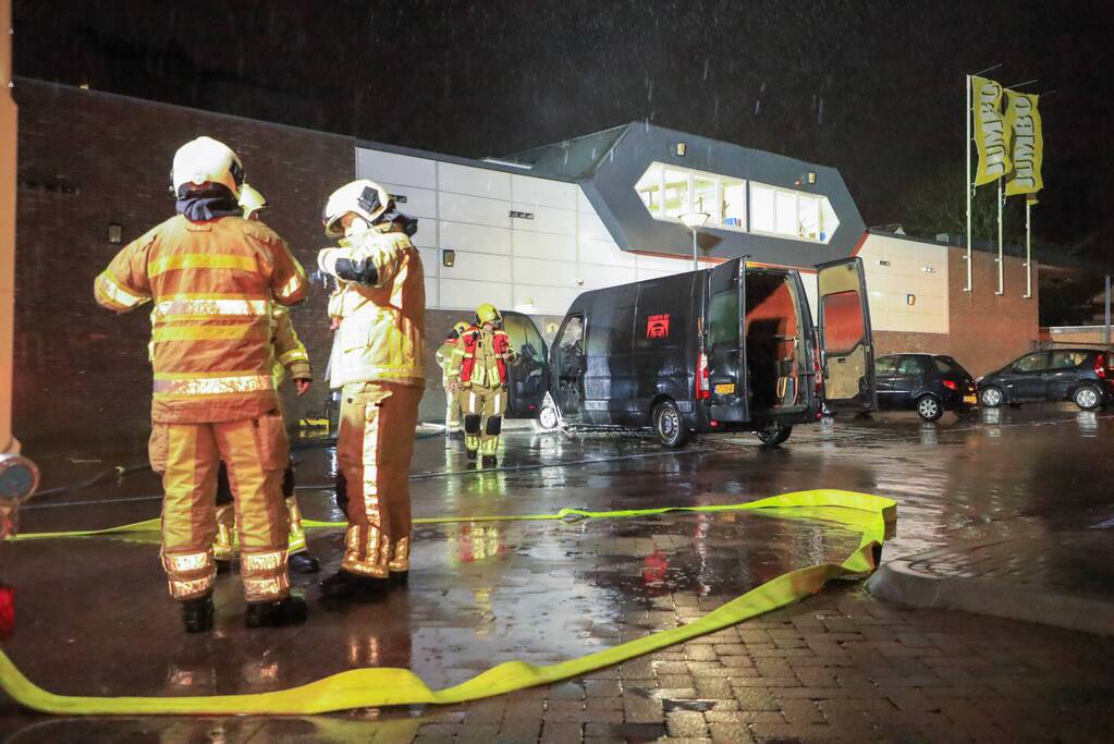 Bestelbus in brand tegen gevel Jumbo
