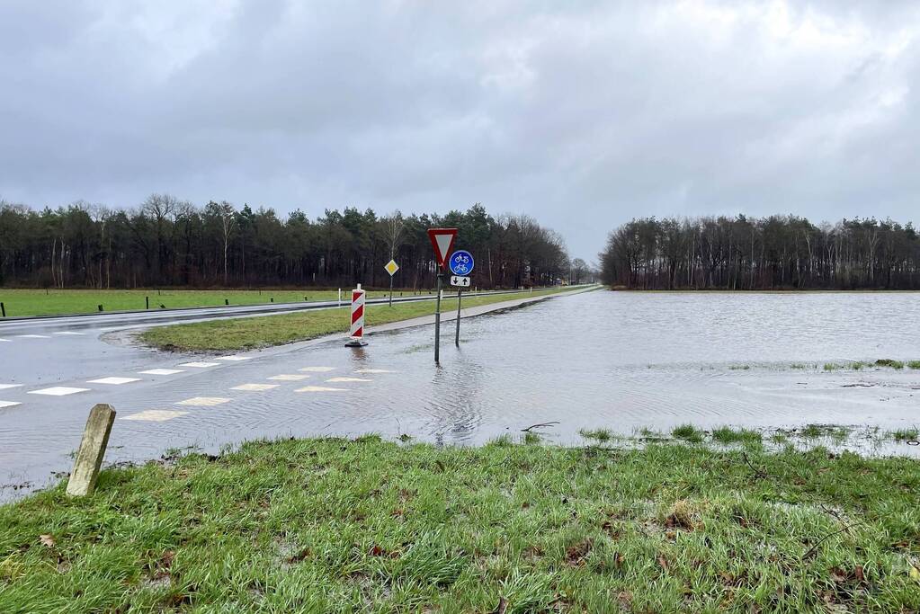 Wegdek en fietspad onder water door hevige regenval