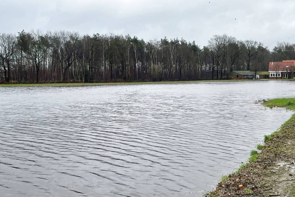 Wegdek en fietspad onder water door hevige regenval