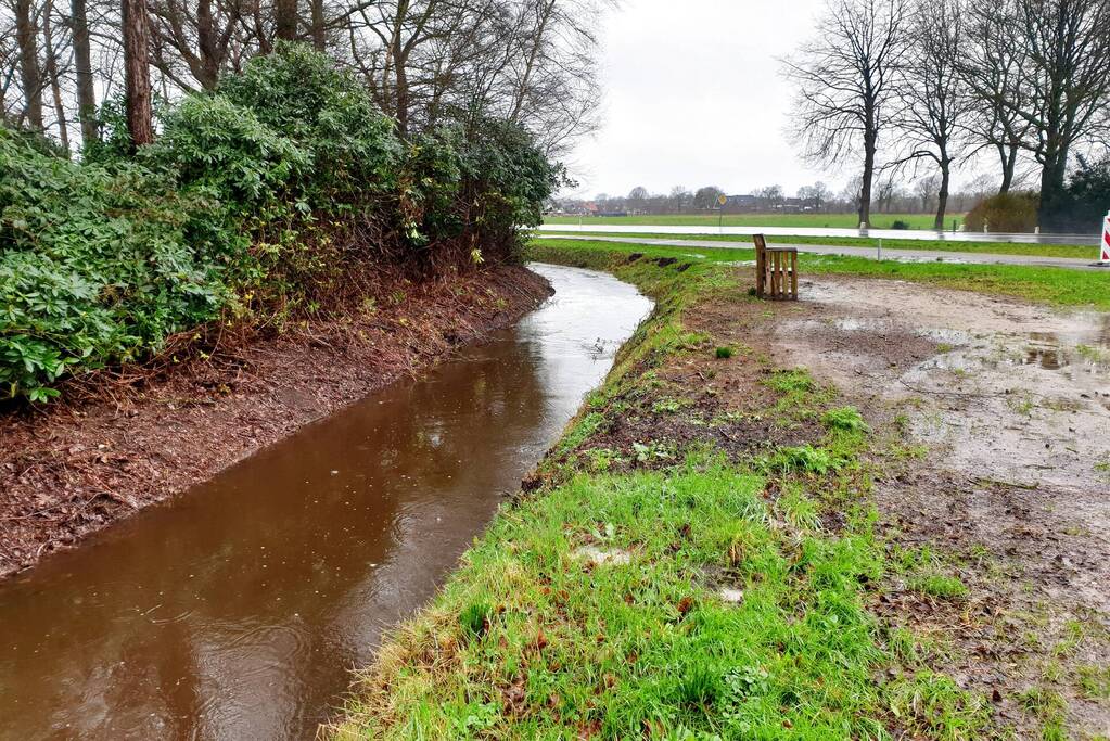 Wegdek en fietspad onder water door hevige regenval