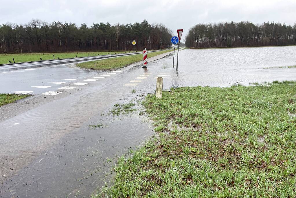 Wegdek en fietspad onder water door hevige regenval