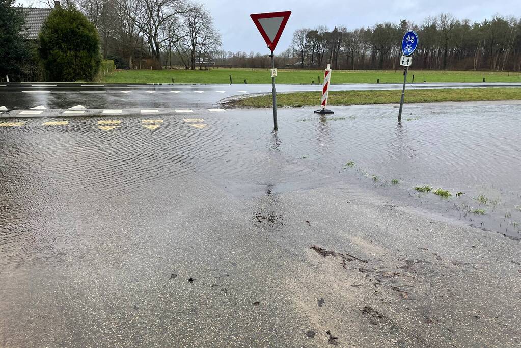 Wegdek en fietspad onder water door hevige regenval