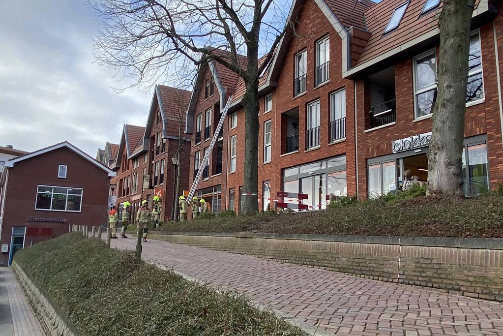 Voetpad afgesloten door losgeraakte dakpannen