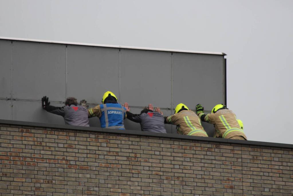 Platen ventilatiesysteem op dak van schoolgebouw waaien los