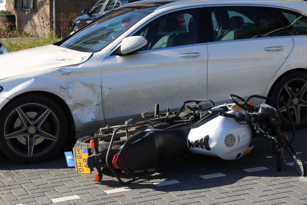 Bestuurder lesmotor knalt op geparkeerde auto