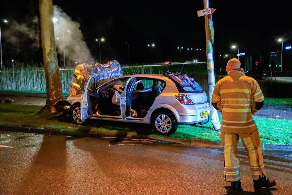 Auto vliegt in brand na botsing tegen boom
