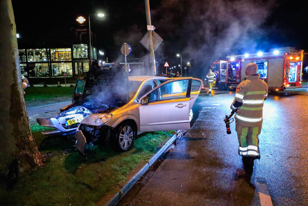 Auto vliegt in brand na botsing tegen boom