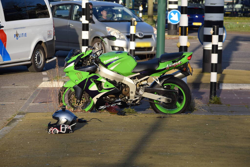 Motorrijder glijdt tegen lijkwagen