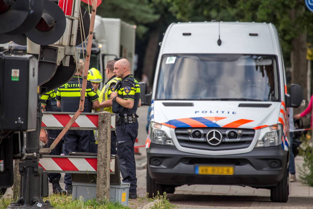 Personenbus belandt op het spoor