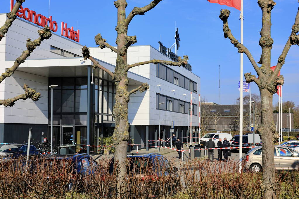 Wild-west-tafereel met automatisch wapen op parkeerplaats Leonardo Hotel