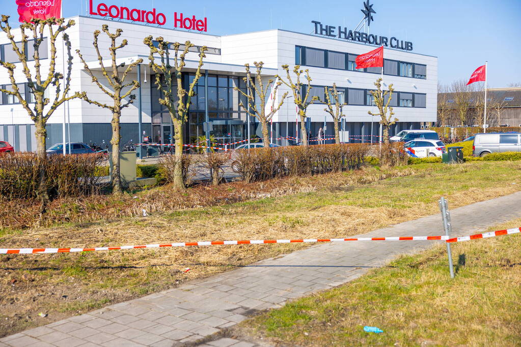 Wild-west-tafereel met automatisch wapen op parkeerplaats Leonardo Hotel