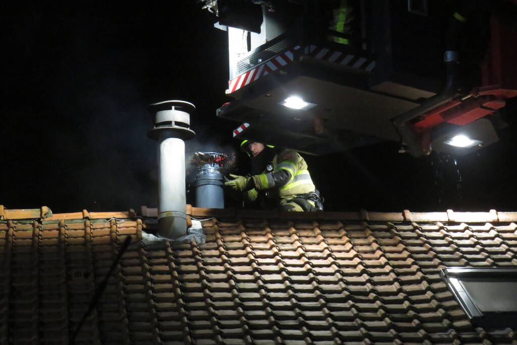 Vonken slaan uit schoorsteen van woning