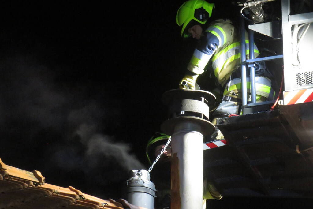Vonken slaan uit schoorsteen van woning