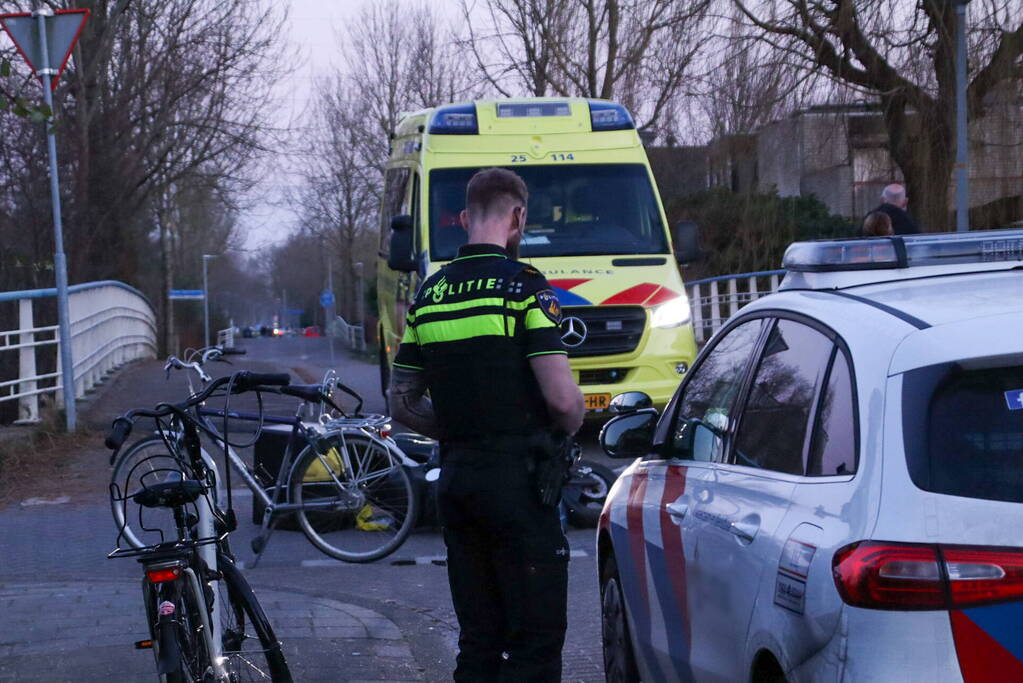 Fietser en bezorger op scooter in botsing