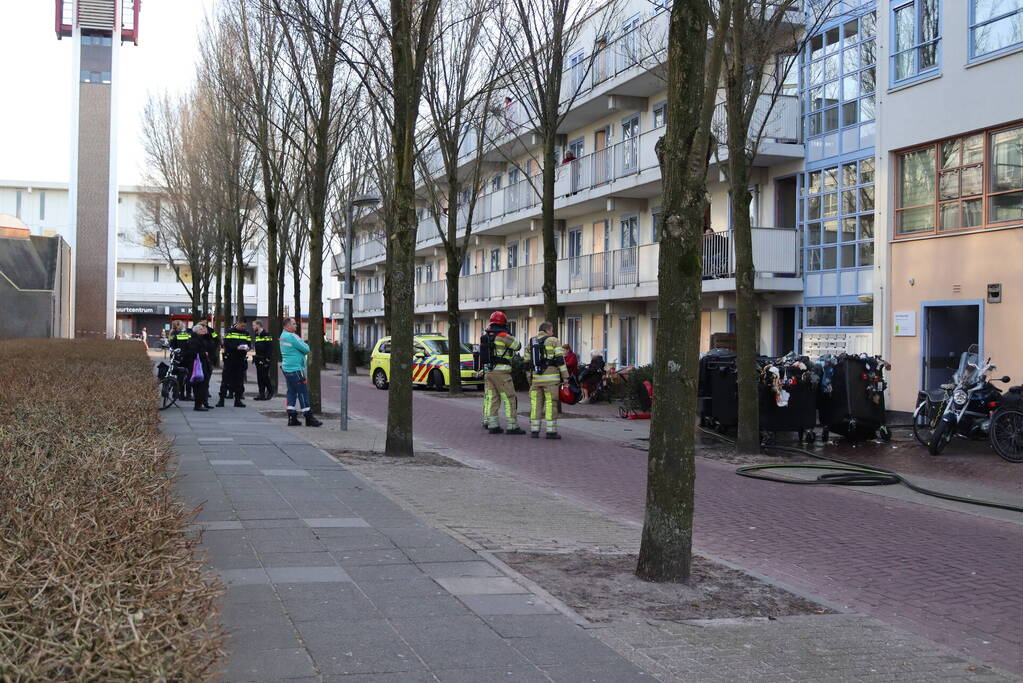 Containers vliegen in brand in flatgebouw