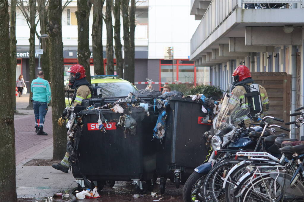 Containers vliegen in brand in flatgebouw