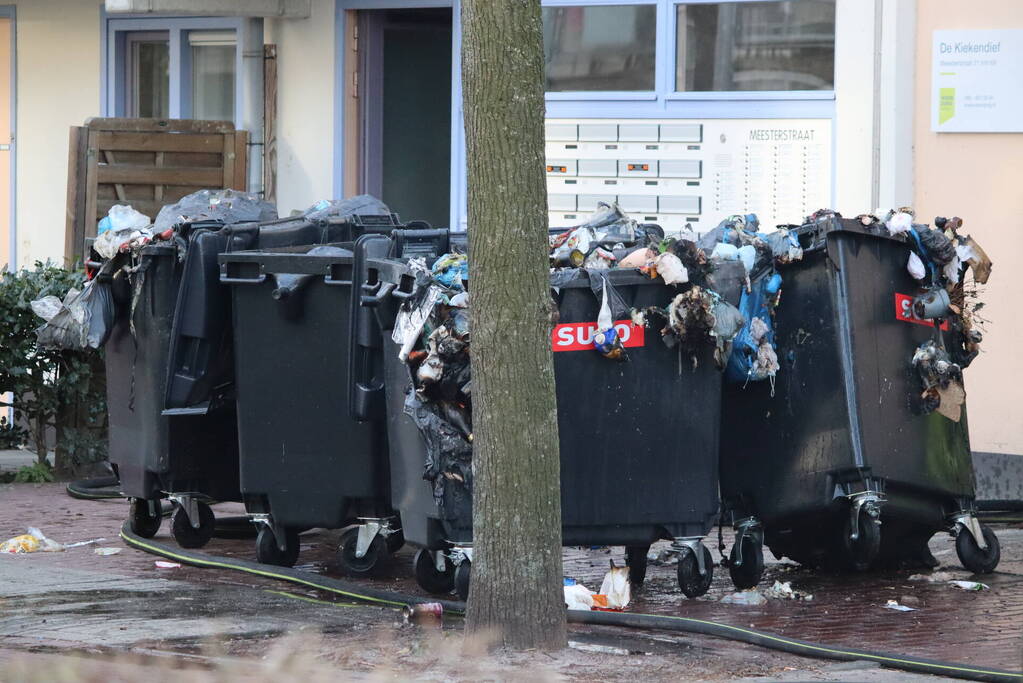 Containers vliegen in brand in flatgebouw