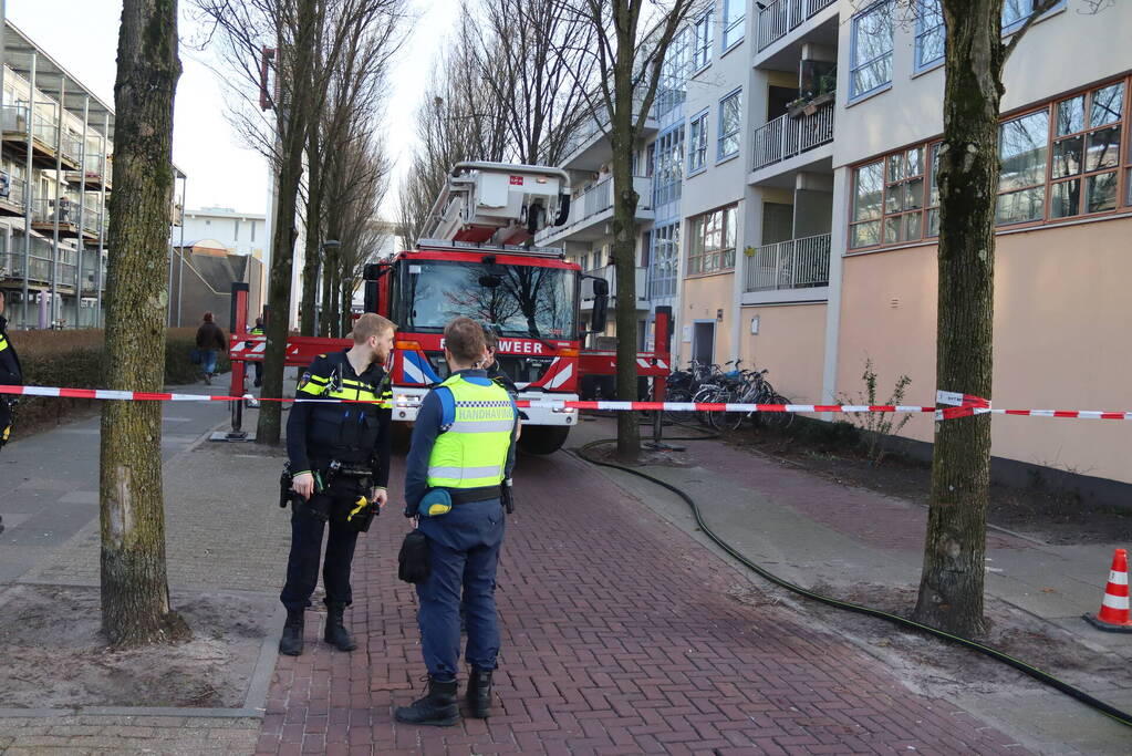 Containers vliegen in brand in flatgebouw