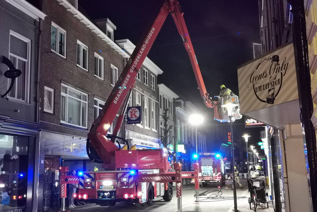 Brandweer blust brand in woning boven winkel