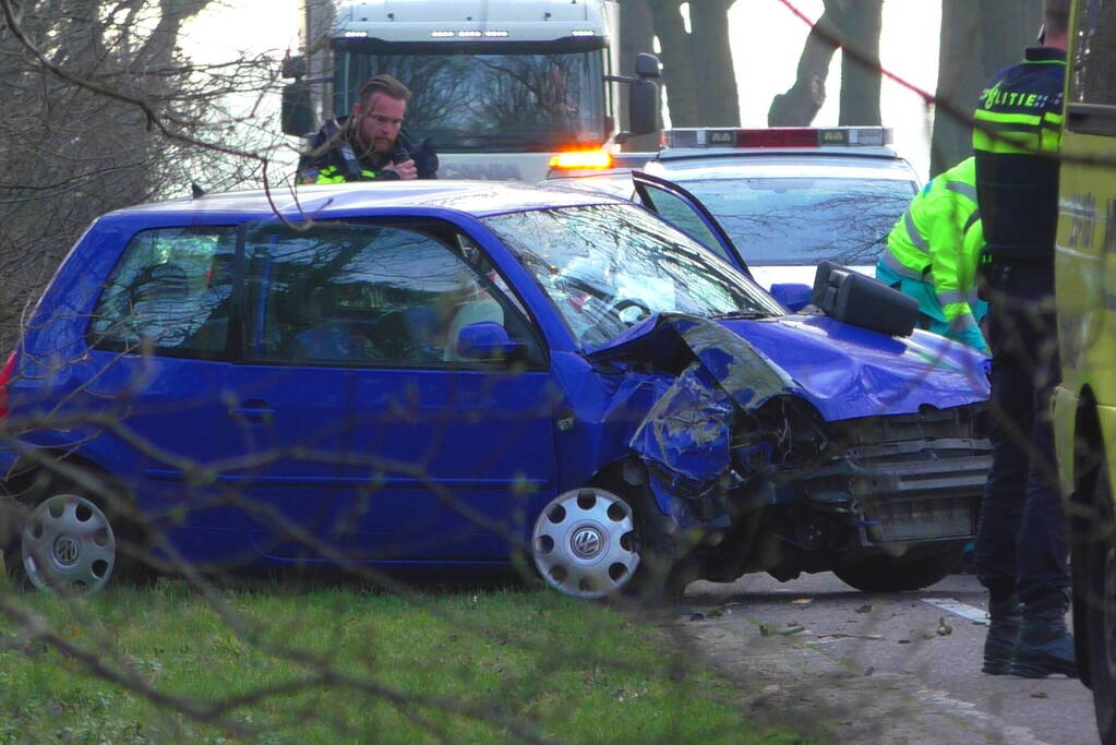 Auto in de kreukels na botsing tegen boom