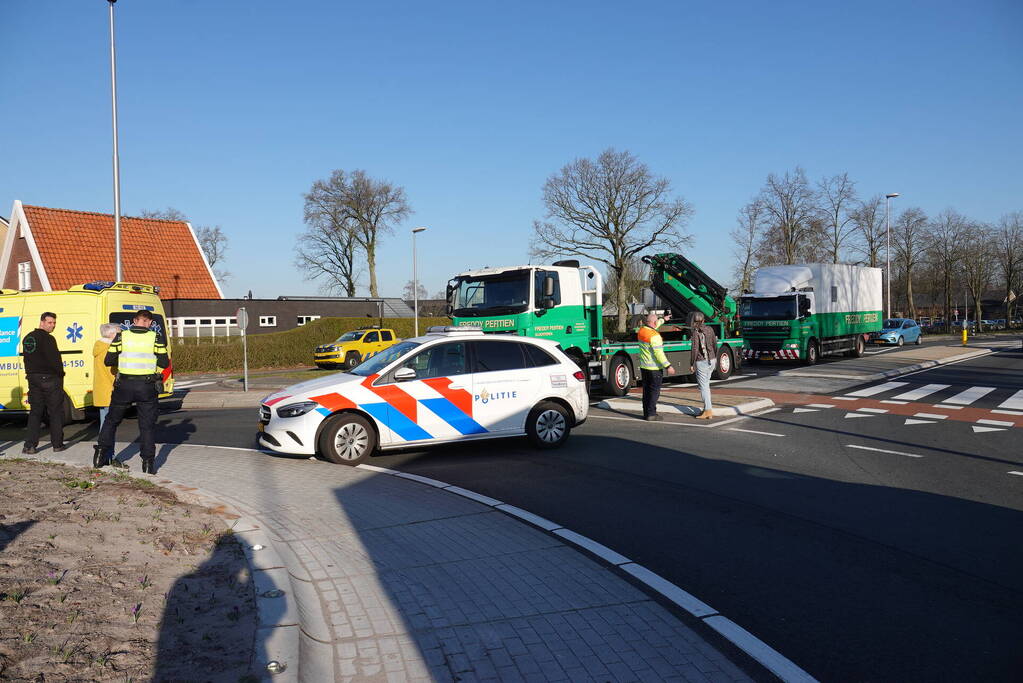 Auto schept e-biker op rotonde