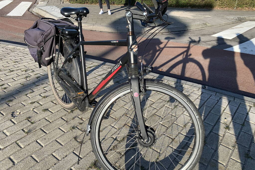 Auto schept e-biker op rotonde