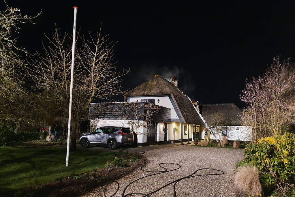 Brand in dak van villa met rietendak