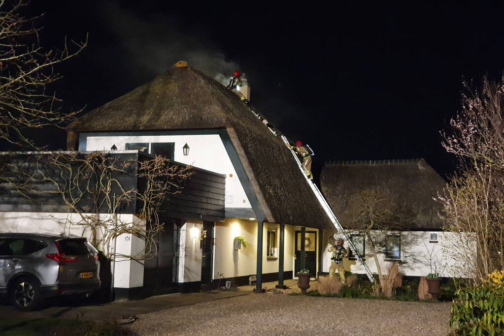 Brand in dak van villa met rietendak