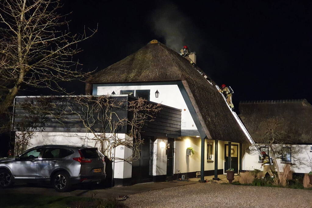 Brand in dak van villa met rietendak