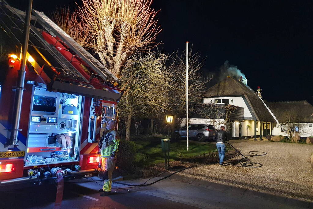 Brand in dak van villa met rietendak