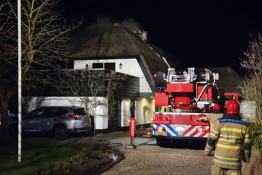 Brand in dak van villa met rietendak