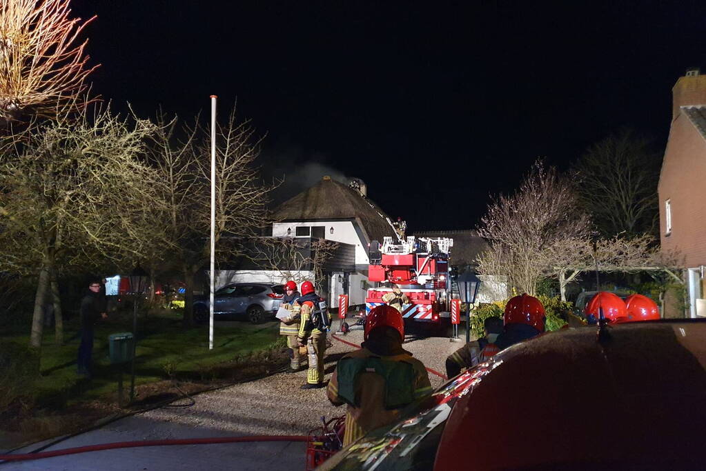Brand in dak van villa met rietendak