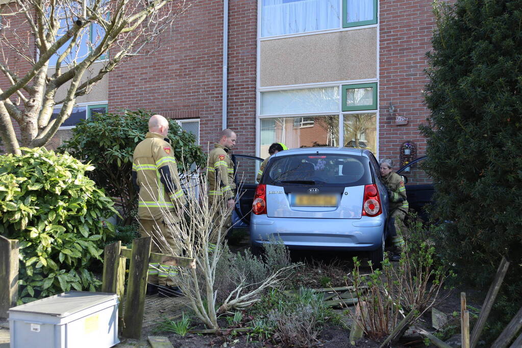 Auto rijdt voortuin van huis binnen
