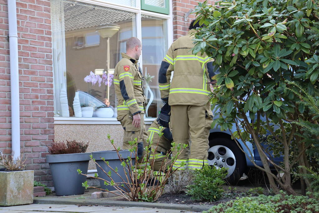 Auto rijdt voortuin van huis binnen
