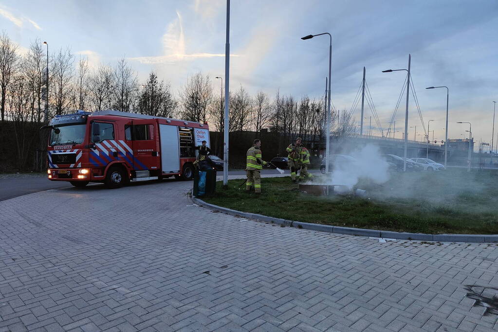 Brandweer blust brandende afvalcontainer