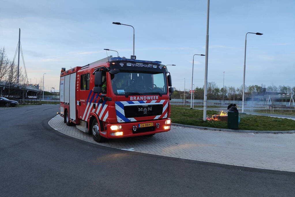 Brandweer blust brandende afvalcontainer