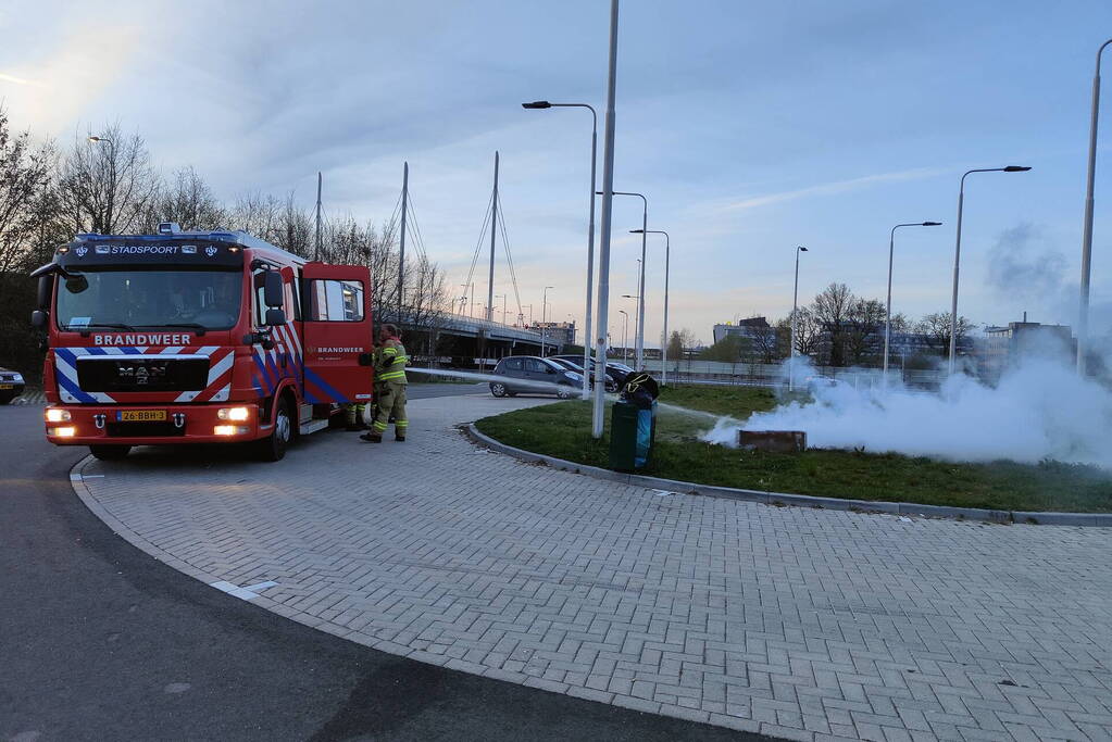 Brandweer blust brandende afvalcontainer