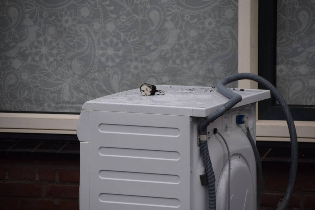 Wasmachine in woning vat vlam