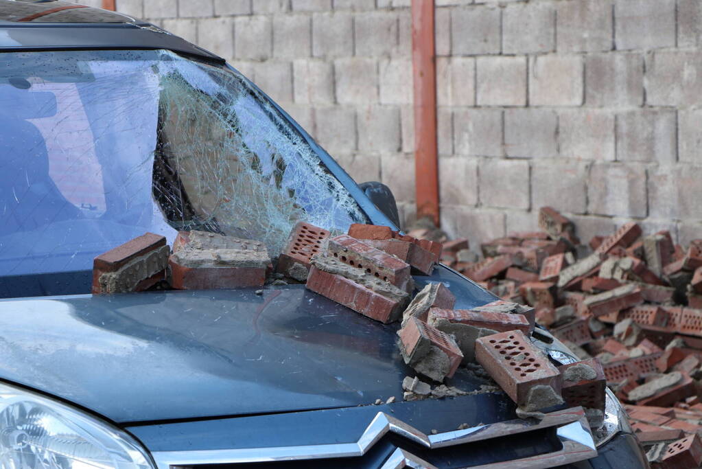 Voertuigen beschadigd na instorten gevel door storm