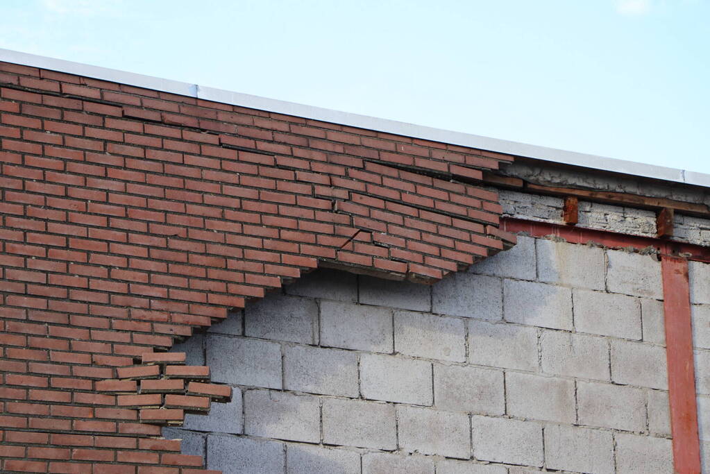 Voertuigen beschadigd na instorten gevel door storm