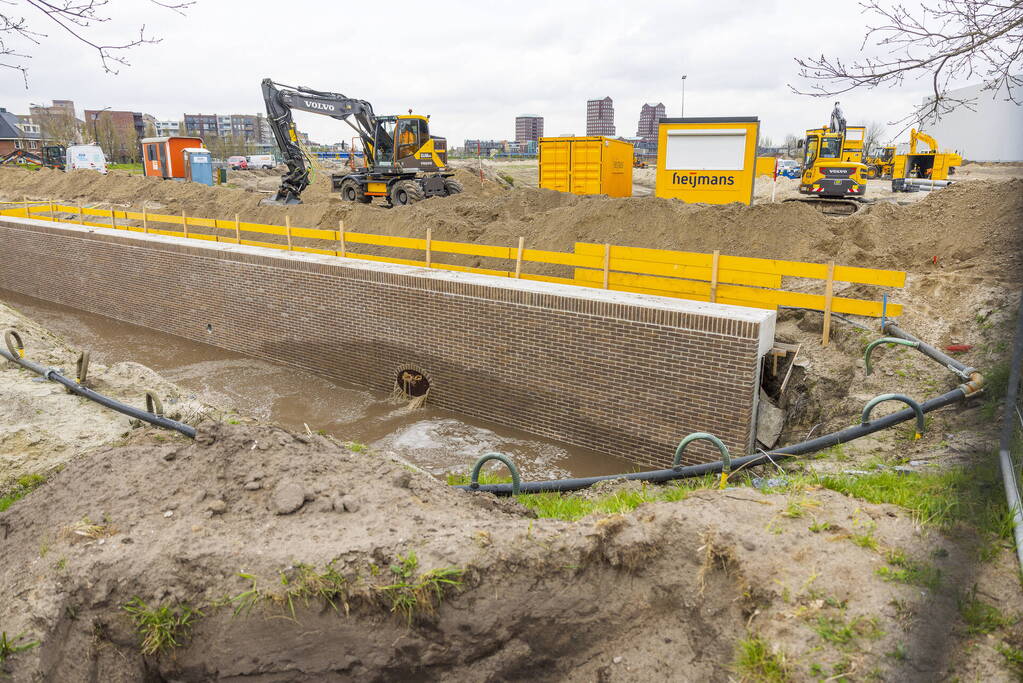 Water spuit uit nieuwe kademuur door gesprongen waterleiding