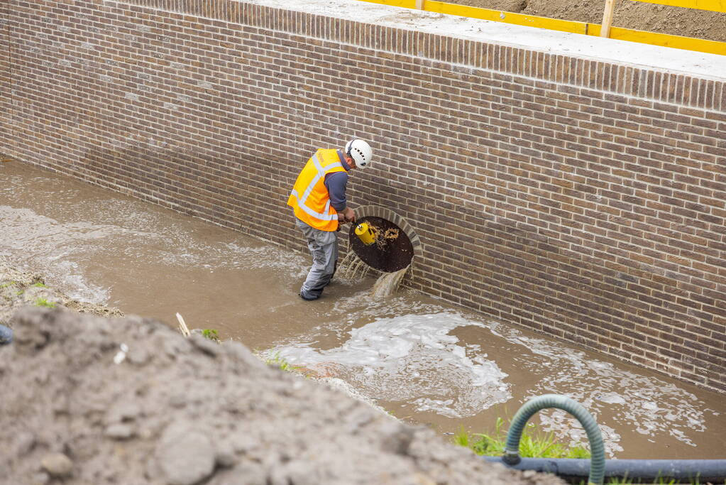 Water spuit uit nieuwe kademuur door gesprongen waterleiding