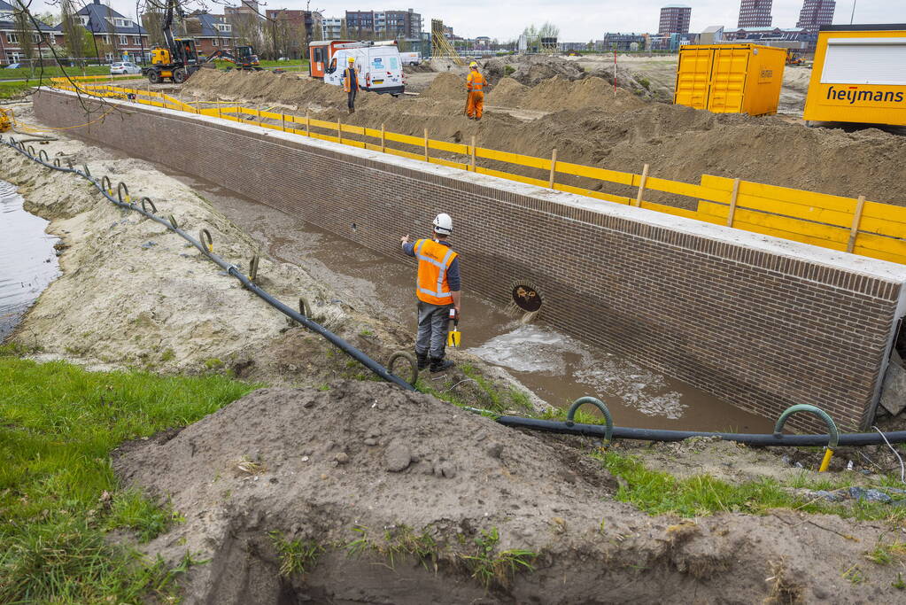 Water spuit uit nieuwe kademuur door gesprongen waterleiding