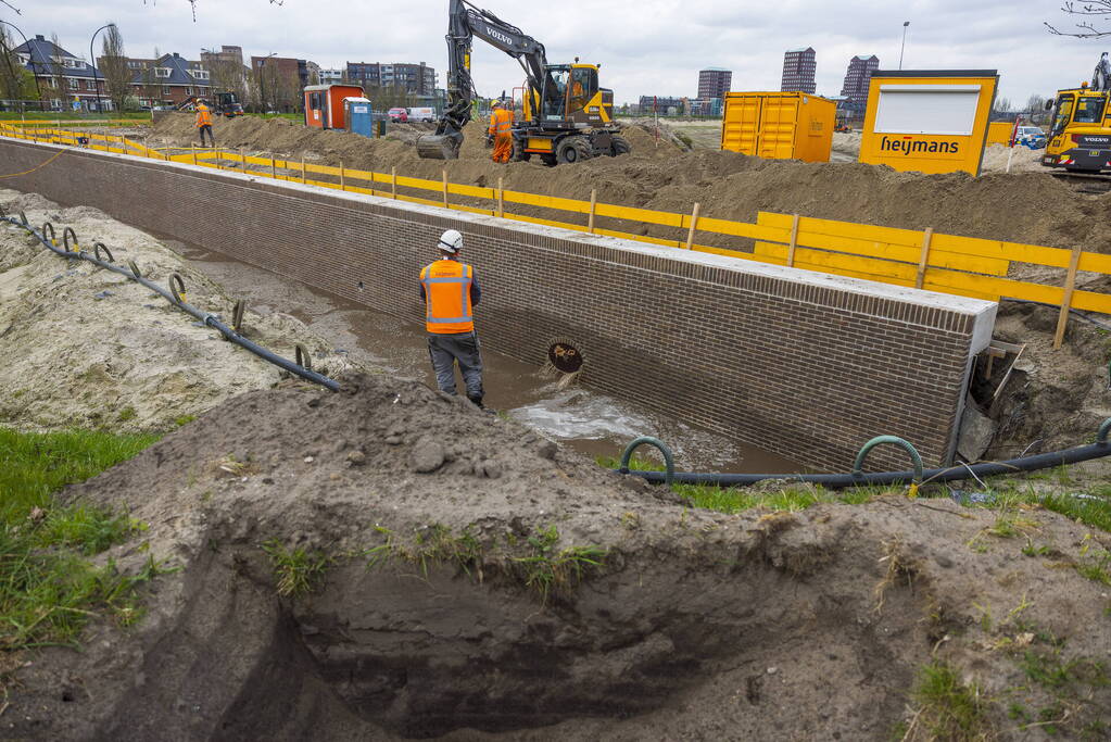 Water spuit uit nieuwe kademuur door gesprongen waterleiding